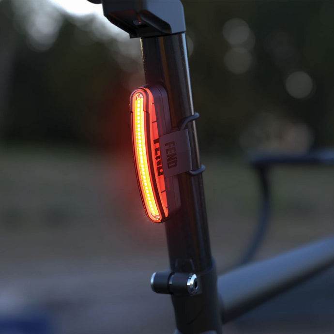 FEND Super Ultra-Bright Bike Tail Light mounted on a bike's seat post, glowing red for improved visibility while cycling.